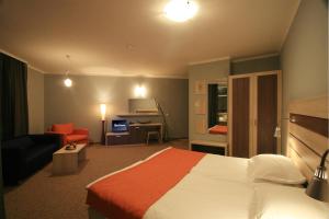 a hotel room with a bed and a living room at Blue Orange Beach Resort in Sozopol