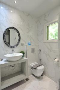 a bathroom with a sink and a toilet and a mirror at Elizabeth Studios in Skiathos Town