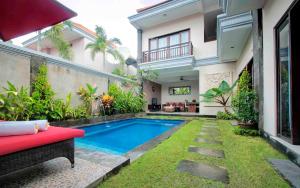 una piscina en el patio trasero de una casa en De' Bharata Bali Villas, en Seminyak