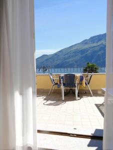 a patio with chairs and a table and a view of the ocean at Hotel Sole - Limone in Limone sul Garda