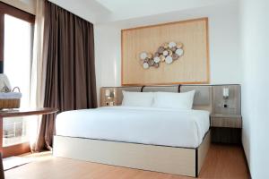 a bedroom with a white bed and a window at Arasatu Villas & Sanctuary in Maratua Atoll