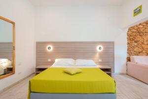 a bedroom with a large bed with a yellow blanket at Bardilio Luxury Rooms in Cagliari