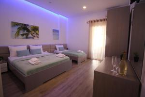 a hotel room with two beds and a lamp at Zero Zero Apartments Sarande in Sarandë