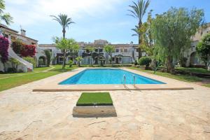 una piscina en un patio con árboles y edificios en Residencial Tropicana by CARLOSFERIEN, en Denia