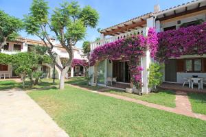 Una casa con flores púrpuras a un lado. en Residencial Tropicana by CARLOSFERIEN, en Denia