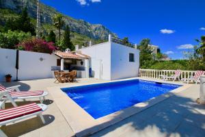 eine Villa mit einem Pool und einem Haus in der Unterkunft Don Quijote LA in Denia
