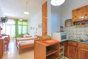 een keuken en een woonkamer met een tafel en een magnetron bij Vista Mare Faros in Gaios