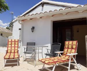 two chairs and a table in front of a house at Casita Adela in Huéscar