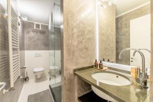 a bathroom with a sink and a shower and a toilet at My Luxury Suites - Executive in Savona