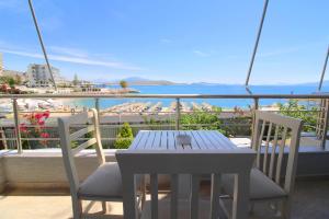 a dining room table with a balcony overlooking the ocean at Zero Zero Apartments Sarande in Sarandë