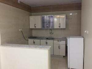 een keuken met een spoelbak en een koelkast bij شقق نيام بارك للشقق المخدومه in Rafha