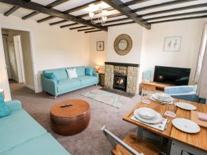 a living room with a blue couch and a table at Duck Egg Cottage in Keighley