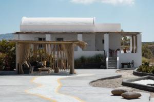 a pavilion with a bed in the middle of a patio at Le Grand Blue Villa in Akrotiri
