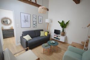 ein Wohnzimmer mit einem blauen Sofa und einem Tisch in der Unterkunft Sweet Jardin des plantes in Paris