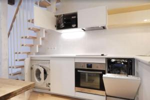 una cucina con piano cottura, lavatrice e asciugatrice di Sweet Jardin des plantes a Parigi