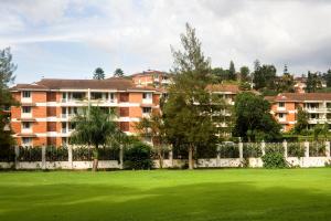 a large building with a green field in front of it at Golf Course Apartments in Kampala