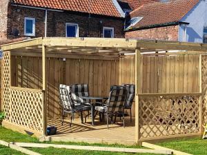 a wooden pergola with a table and chairs on a deck at Travellers Rest Apartment in Beverley