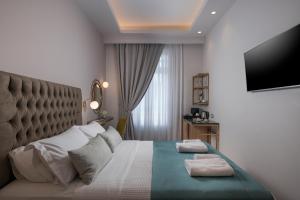 a bedroom with a bed with two towels on it at Plaza 1866 Superior City Rooms in Chania Town
