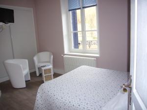 een slaapkamer met een bed en 2 stoelen en een raam bij Chambres d'hôtes Résidence du Parc in Plombières-les-Bains