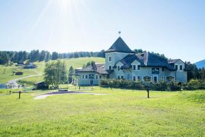 a large house on a hill with a green field at Villa Pana in Santa Cristina in Val Gardena