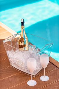 a bottle of champagne in a glass tray next to a pool at Evala luxury rooms with pool and garden in Split