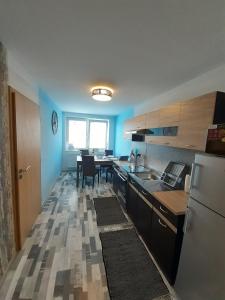 kuchnia z lodówką i stołem z krzesłami w obiekcie Apartmán s privátní VÍŘIVKOU w mieście Bzenec