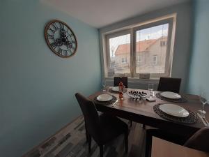 stół jadalny z krzesłami i zegarem na ścianie w obiekcie Apartmán s privátní VÍŘIVKOU w mieście Bzenec +2 zdjęcia