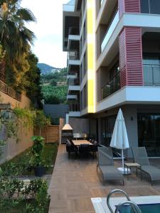 een gebouw met een patio met stoelen en een parasol bij Cleopatra Sultan Residence in Alanya