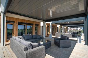 un patio con sofás y sillas en una terraza en DOMKI CAŁOROCZNE STELLA PUCK en Puck