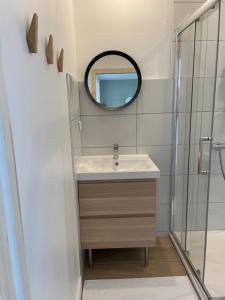La salle de bains est pourvue d'un lavabo et d'un miroir. dans l'établissement Réalaplage studio de charme sur Rivedoux, à Rivedoux-Plage