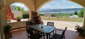 a patio with a table and chairs and a view of the water at House with View in Amfithea in Ioannina
