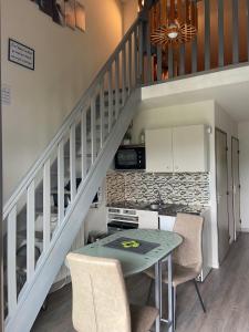 a kitchen with a table with chairs and a staircase at Appartement Hauteur Barcelonnette Vue Exceptionnelle in Barcelonnette