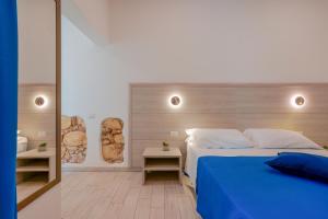 um quarto com uma cama azul e duas mesas em Bardilio Luxury Rooms em Cagliari