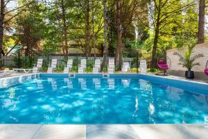 a swimming pool with chairs and trees at Wellness СПА-Отель Грейс Калифорния in Adler