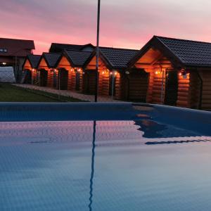 einen Pool vor einer Reihe von Häusern bei Sonnenuntergang in der Unterkunft Christiana-Rent in Cristian