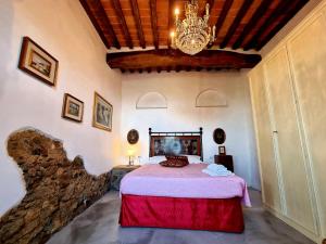 a bedroom with a bed and a chandelier at Casa L Oliveta in Montemagno