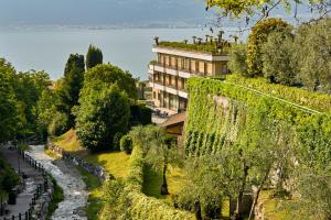 un bâtiment situé au sommet d'une colline à côté d'une rivière dans l'établissement Hotel Royal Village, à Limone sul Garda