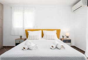 una camera da letto con un letto bianco e asciugamani di Villa del Fior a Aigio
