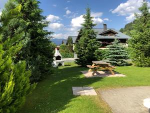 stół piknikowy na dziedzińcu z drzewami i domem w obiekcie Familienappartements Eder - Free entry to Tauern SPA Kaprun included w Kaprunie