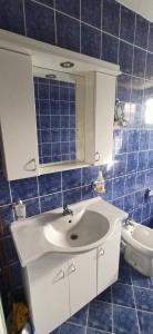 a bathroom with a white sink and blue tiles at Vila Nikola & Aleksa in Vrnjačka Banja