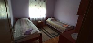 two beds in a small room with a window at Vila Nikola & Aleksa in Vrnjačka Banja