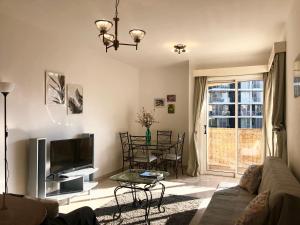 a living room with a couch and a tv and a table at 1 bedroom flat, prime location near sea, sleeps 4 in Limassol