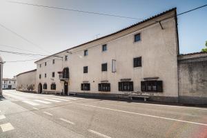 Une rue vide avec un grand bâtiment sur le côté dans l'établissement Guesthouse Muha, à Lipica