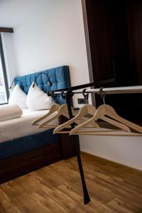 a room with a bed and a chair with hangers at SleepWell24 in Spittal an der Drau