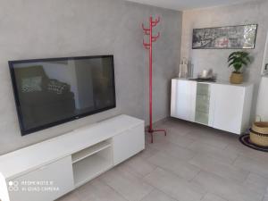 un salon avec une télévision à écran plat sur un mur dans l'établissement Apartamento en primera línea de playa, à Sanlúcar de Barrameda