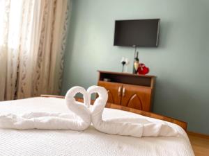 コンスタンツァにあるDany's Apartment Constantaのハートのような白鳥がベッドの上に座っている