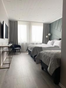 Habitación de hotel con 2 camas y escritorio en Midtown Hotel en Reikiavik