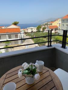 a table on a balcony with a view of the ocean at Apartments Adria in Baška Voda