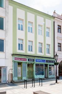 a green and white building on a city street at Apartmány Velké náměstí in Kroměříž