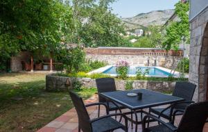 eine Terrasse mit Tisch und Stühlen und ein Pool in der Unterkunft Gorgeous Hideout in Mostar